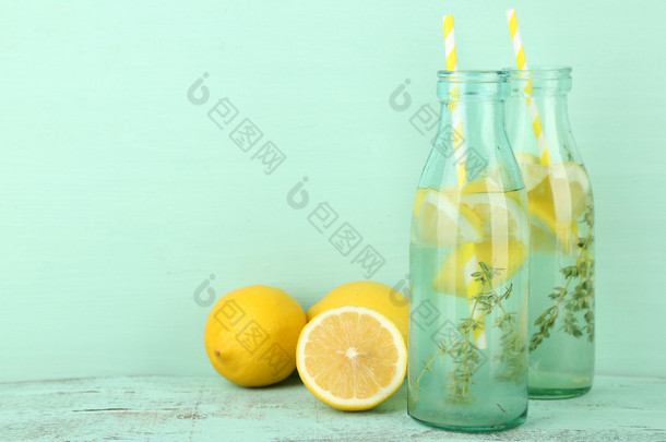 美味清凉饮料的柠檬和百里香，木制的背景上