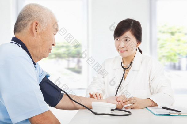 医生测量血压的老人在家里