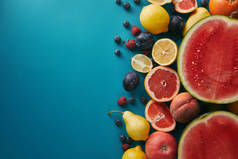 蓝色表面葡萄柚、柠檬和浆果的顶部视图