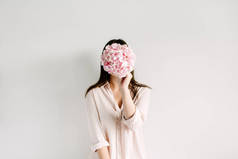 年轻女子举行粉红色绣球花花束在白色背景。花卉美容时尚理念.