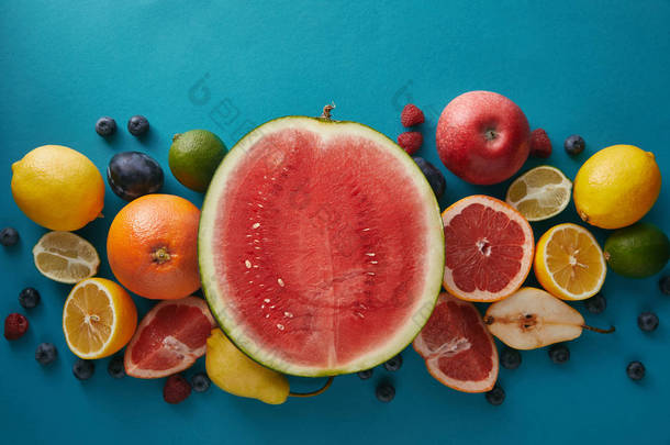 在蓝色表面上的西瓜、葡萄柚和浆果的顶端视图 