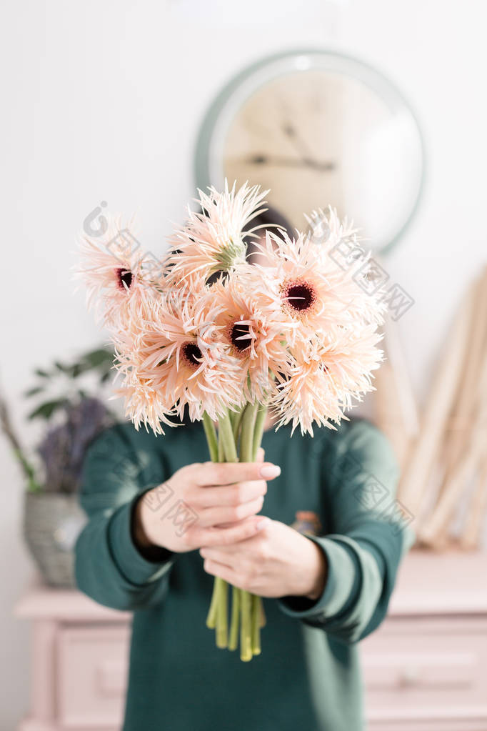 美丽的春天花花束柔弱的雌手捧着淡粉色的在