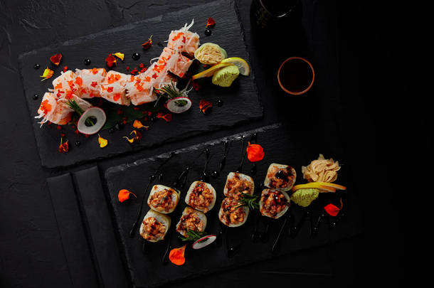 在石板板和筷子上的美味新鲜寿司卷的顶级视图