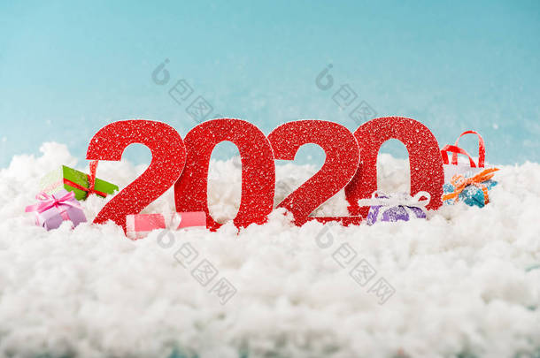 数字2020和白雪中的圣诞礼品盒 