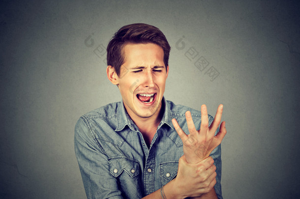 Young man holding his painful wrist. Sprain pain