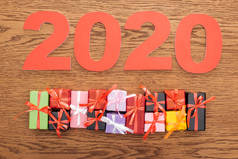 靠近木制背景的小装饰礼品盒的2020年纸牌号顶部视图