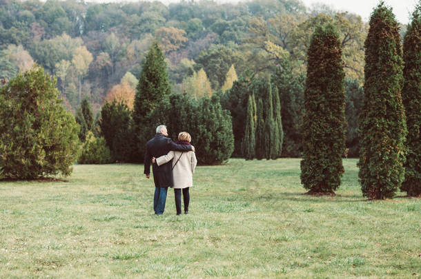 成熟的夫妇走在秋天的公园