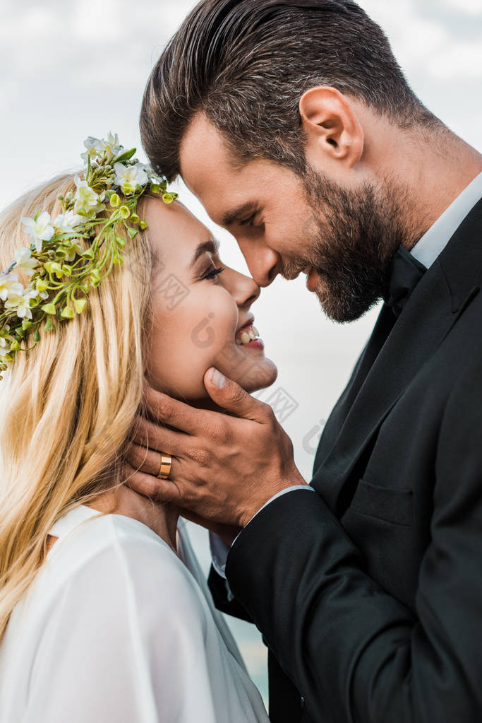 婚纱夫妇的肖像和白色礼服触摸海滩上的鼻子