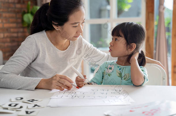 母亲和女儿<strong>在家</strong>里<strong>学习</strong>读书写字