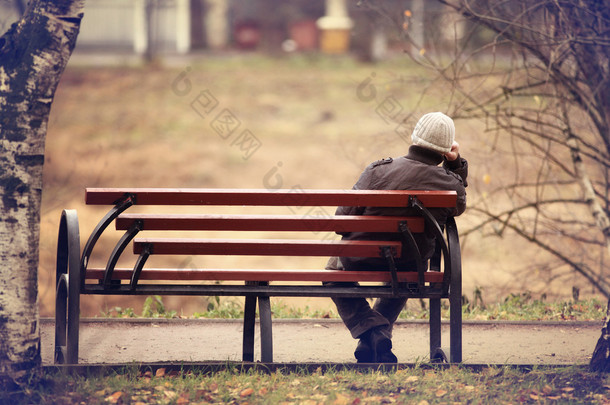 孤独的人上的长椅上秋雨