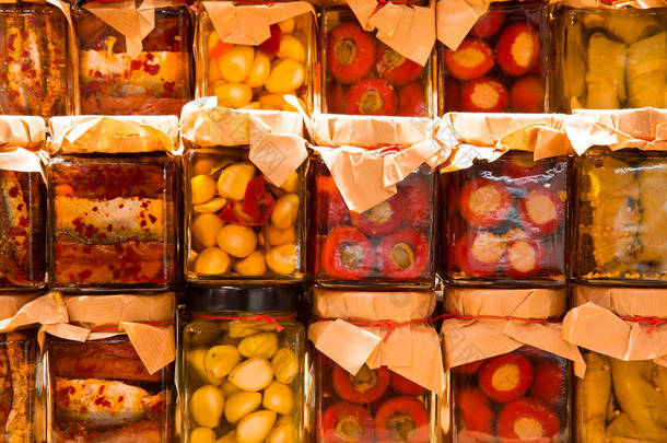 许多罐子与保存的意大利食物与蔬菜和 sardi
