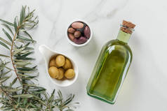 大理石表面的橄榄油和美味橄榄的顶部视图