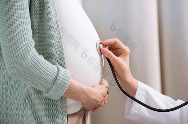 医生听力孕妇的肚子里 