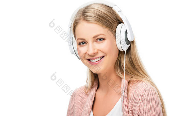 微笑的妇女听音乐, 使用耳机和看相机孤立的白色