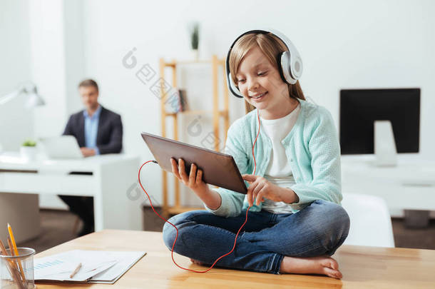 精明的小女孩玩她的平板电脑