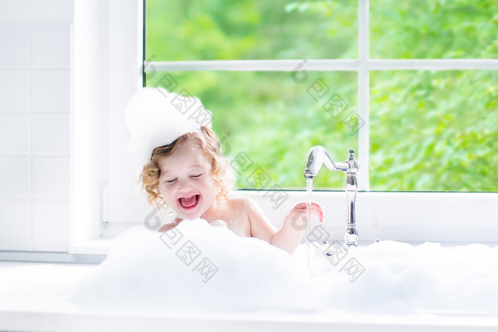 Baby girl taking bath with foam