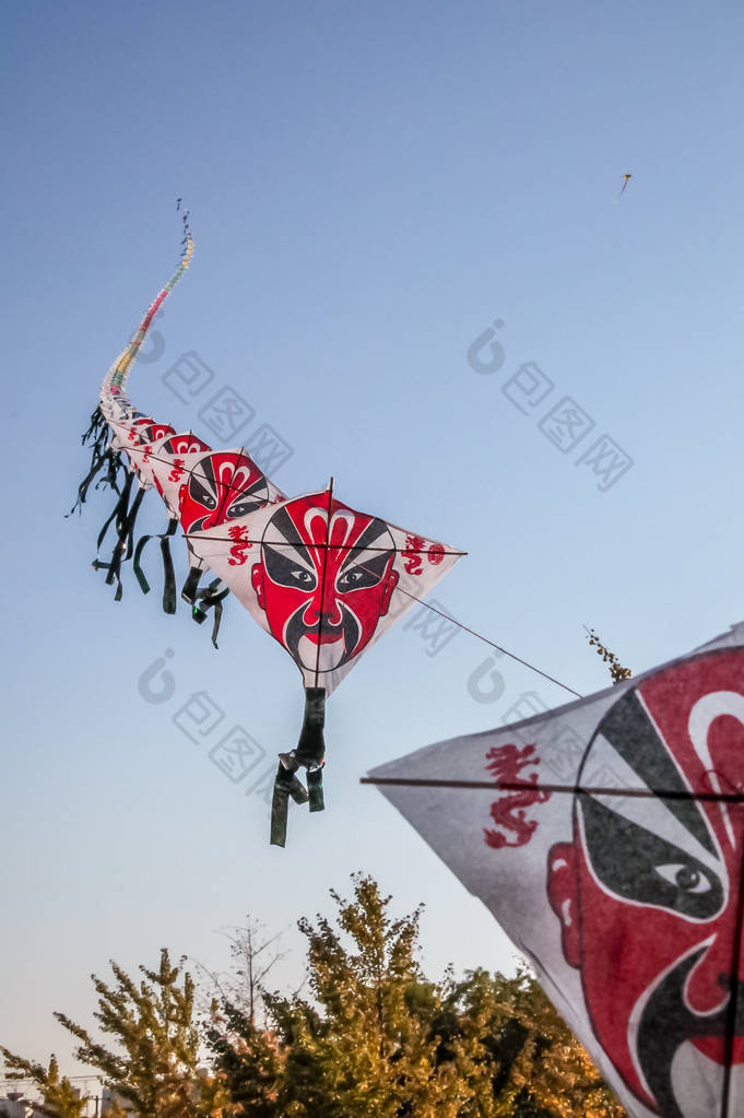 一排排中国纸风筝在晴朗的蓝天上飞翔