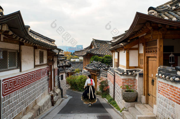 在韩国首尔 Bukchon 韩屋友楼村的首尔传统风格的<strong>房子</strong>里, 穿着韩的亚洲女<strong>人</strong>回来了。.