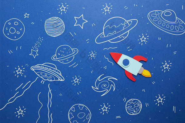 创意火箭在蓝色纸背景与宇宙图标