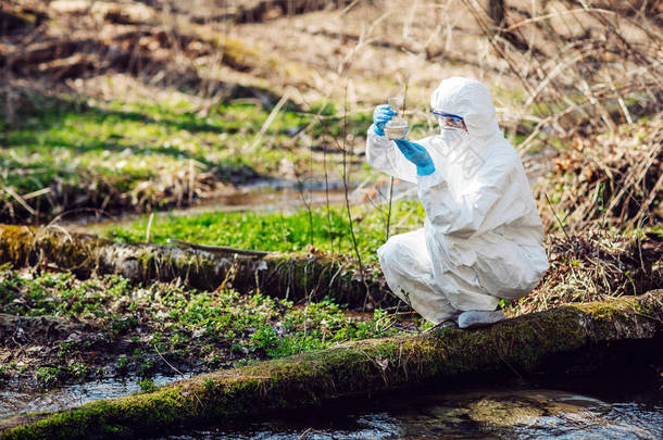 一个女科学家的特写, 检查在森林中的烧瓶的液体含量。生态与环境污染概念.