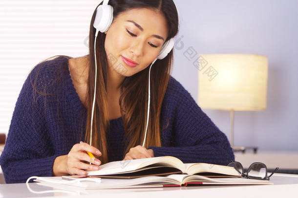 亚洲女人一边做作业一边听音乐