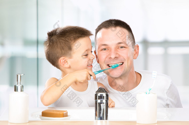 微笑的孩子跟爸爸在浴室刷他的牙