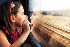 从窗口看的小女孩。她在火车上旅行.