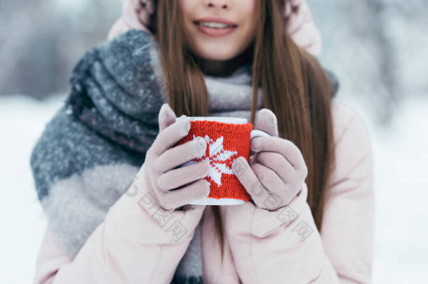 在雪地公园手里拿杯热咖啡的妇女选择<strong>重点</strong>