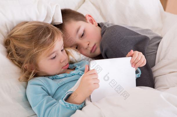 可爱的小小的女孩和男孩读睡前故事