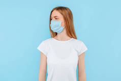 保护自己免受传染病的侵袭，考拉威斯。一个年轻的女孩戴着一个卫生面具来防止感染，空气传播的呼吸道疾病。在蓝色背景上隔离的闭合演播室镜头