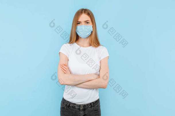 保护自己免受<strong>传染病</strong>的侵袭，考拉威斯。一个年轻的女孩戴着一个卫生面具来防止感染，空气传播的呼吸道疾病。在蓝色背景上隔离的闭合演播室镜头