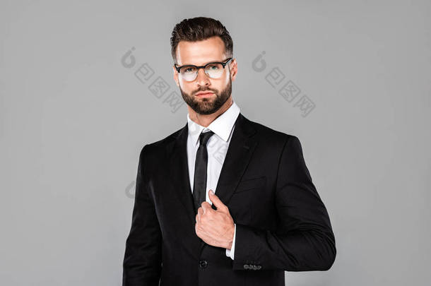 严重成功<strong>的</strong>商人在黑色西装和眼镜隔离在灰色