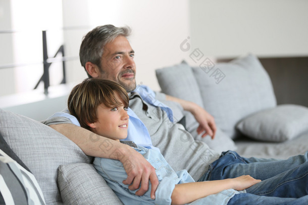 父亲和儿子躺在沙发上，