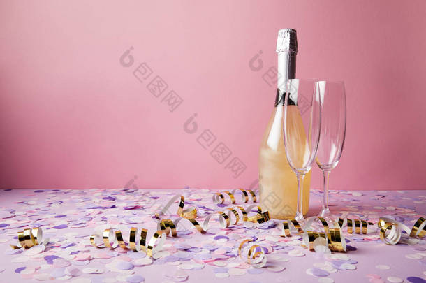 一瓶香槟, 眼镜和五彩纸屑在紫罗兰桌面上