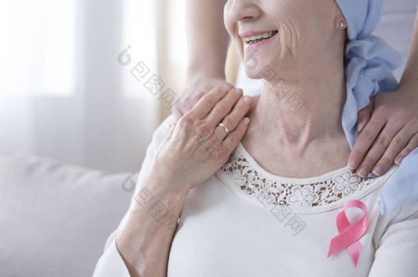 特写微笑的<strong>老年</strong>妇女以粉红色丝带作为抗击乳腺癌的标志