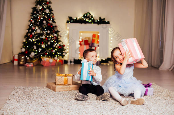 小男孩和女孩打开圣诞礼物新年<strong>冬天</strong>圣诞树