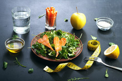 Concept diet food. Salad with arugula, leaf mash and carrots on a dark background. Vegetarian health