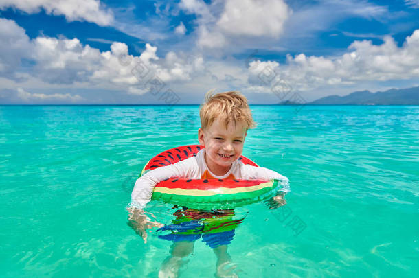 塞舌尔海滩上3岁的小男孩带着充气环游泳