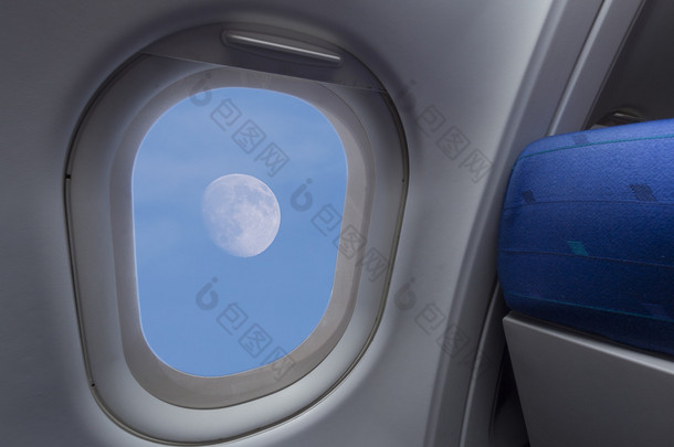 通过<strong>飞机</strong>窗口看到的月亮在天空中