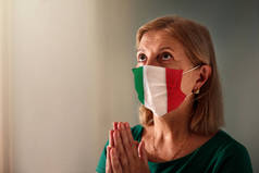 为意大利祈祷吧戴面具的女人在祈祷在大肠病毒爆发期间，住在医院小礼拜堂或教堂的老年病人。病毒大流行人们崇拜。护士为生病的意大利病人祈祷.