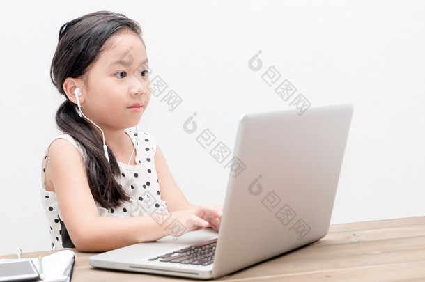 可爱的女生女孩与桌上的笔记本电脑电脑 