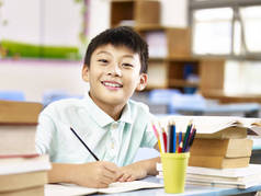 亚洲小学男生在教室里做作业