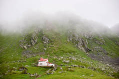 孤独的房子在山谷 Fagaras 山脉, 特兰西瓦尼亚, 罗马尼亚, 欧洲。群山笼罩着迷雾.