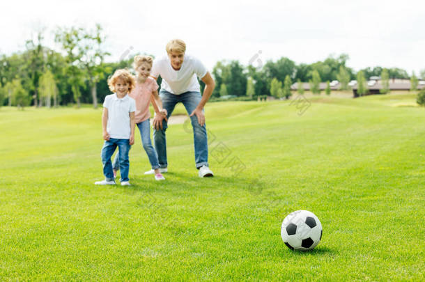 父亲与孩子们在公园里<strong>的</strong>踢足球