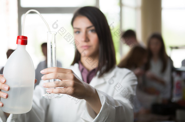 Scientific researcher holding a distilled purified deionised water in plastic bottles with a pump. M