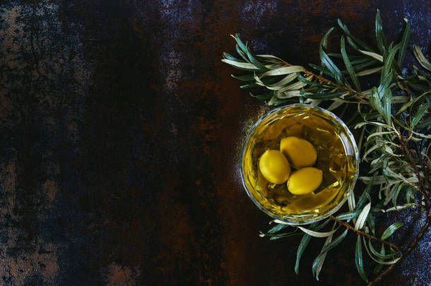 大理石桌上的橄榄油和树枝的顶部视图