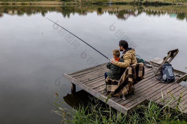 父亲和儿子在码头钓鱼