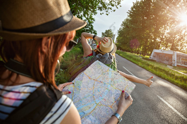 在公路上搭便车的旅游女孩