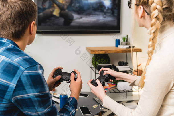两个青少年玩电子游戏的背面视图