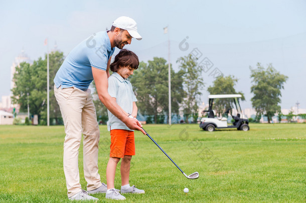 man teaching his son to play golf